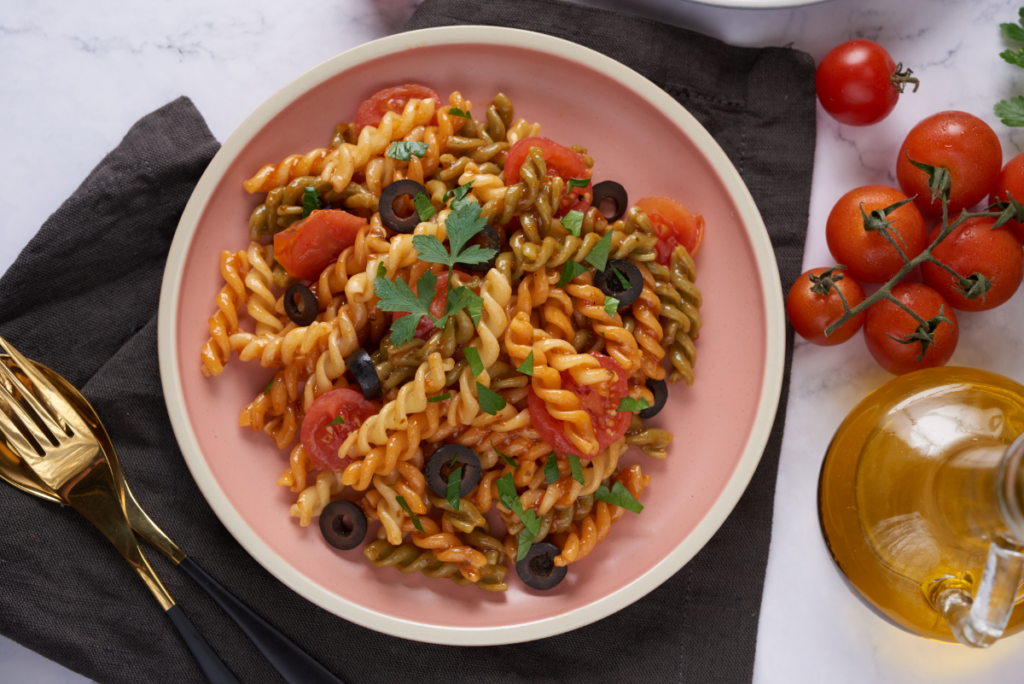 A bowl of gemelli pasta with marinara sauce, highlighting its twisted shape and texture